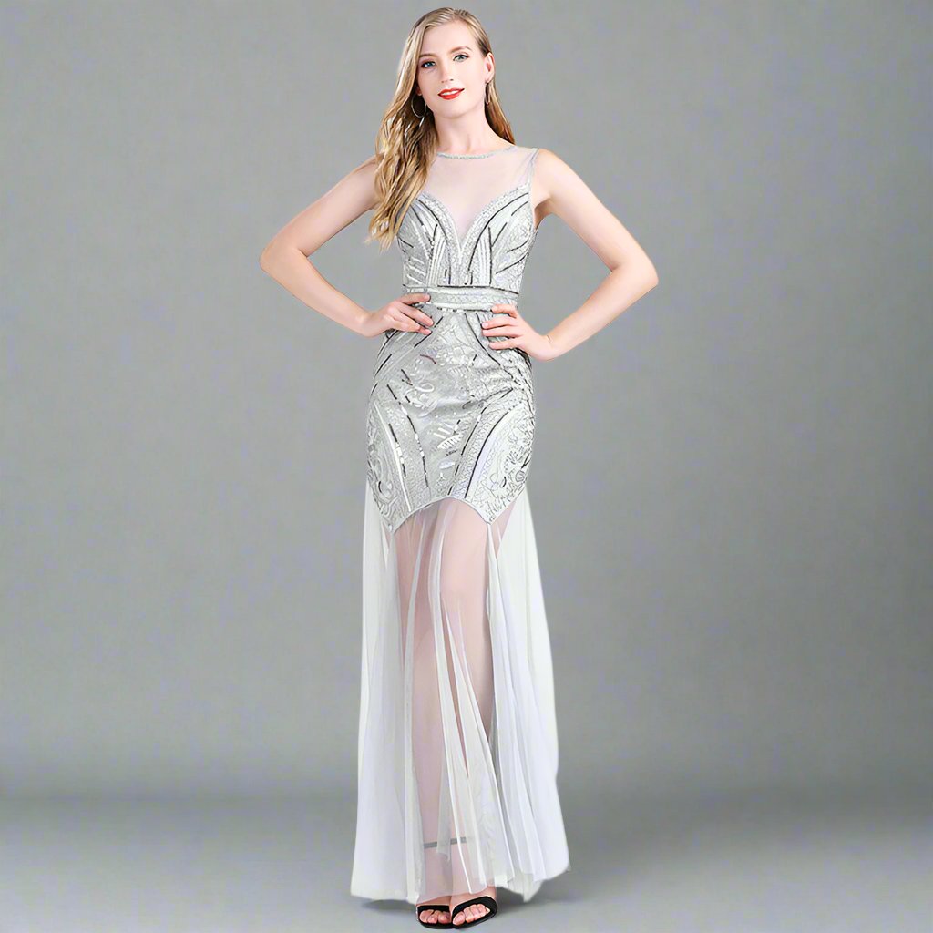 A model wearing an elegant, sleeveless, mini dress with a geometric pattern in black, white, and silver colors, featuring a high neck and a mid-calf length.