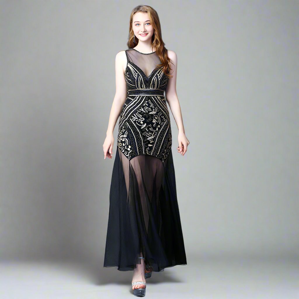 A model wearing an elegant, sleeveless, mini dress with a geometric pattern in black, white, and silver colors, featuring a high neck and a mid-calf length.