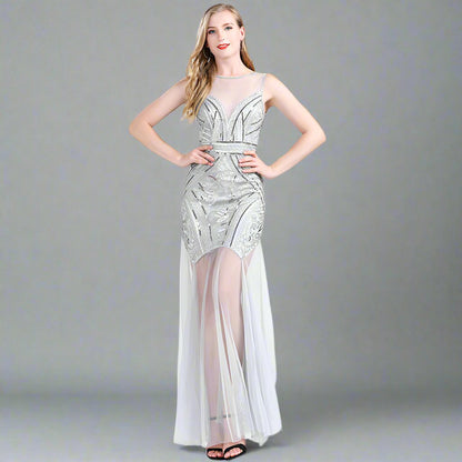 A model wearing an elegant, sleeveless, mini dress with a geometric pattern in black, white, and silver colors, featuring a high neck and a mid-calf length.