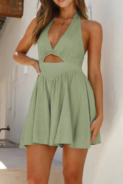 Woman wearing a green halter dress with cut-out design 